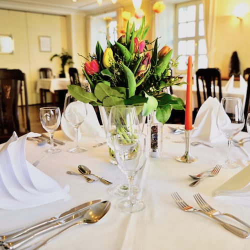 Gedeckter Tisch mit frischen Blumen im Restaurant Post